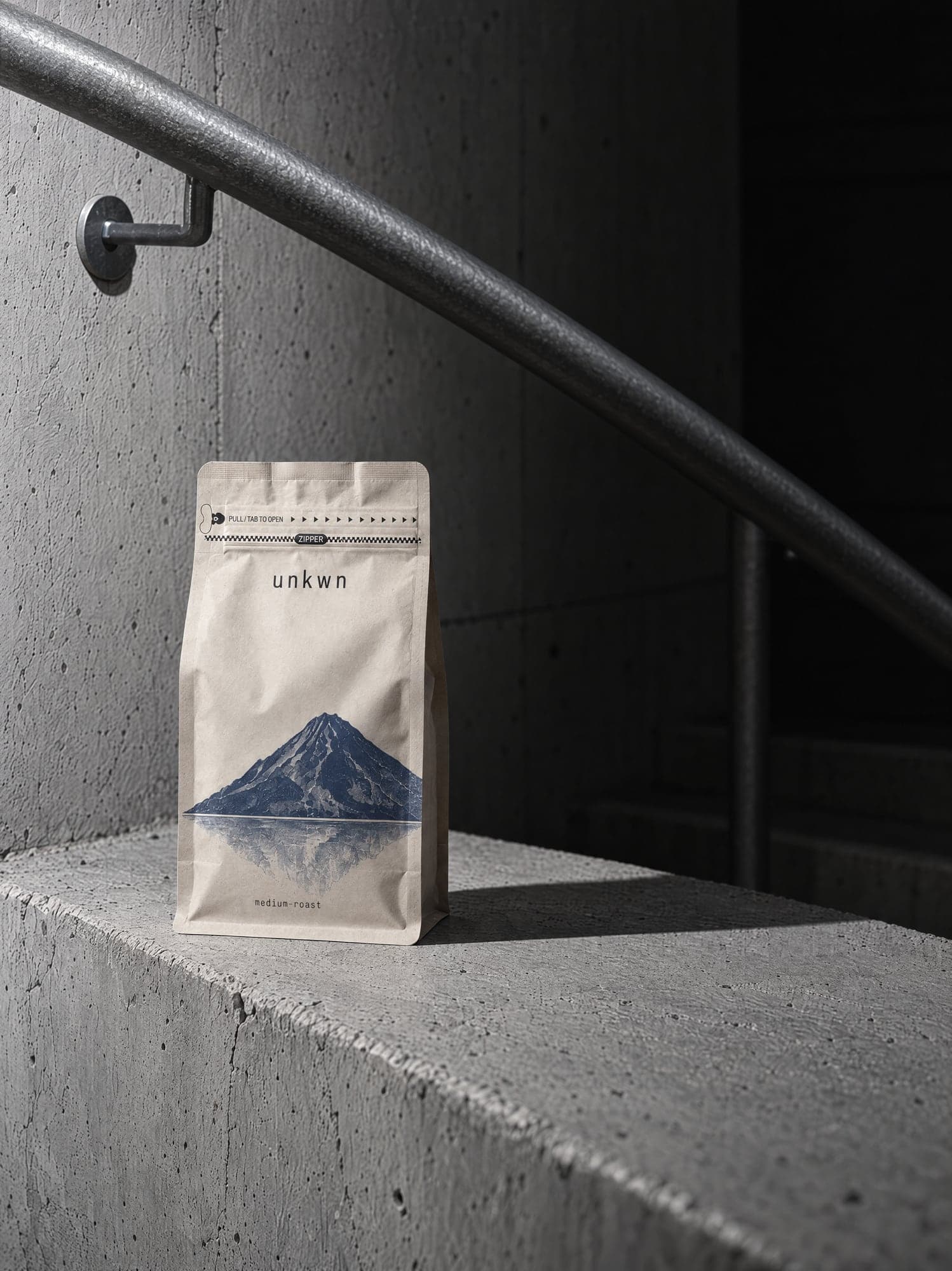 An unkwn bag on a concrete ledge beneath a steel handrail, hard flash