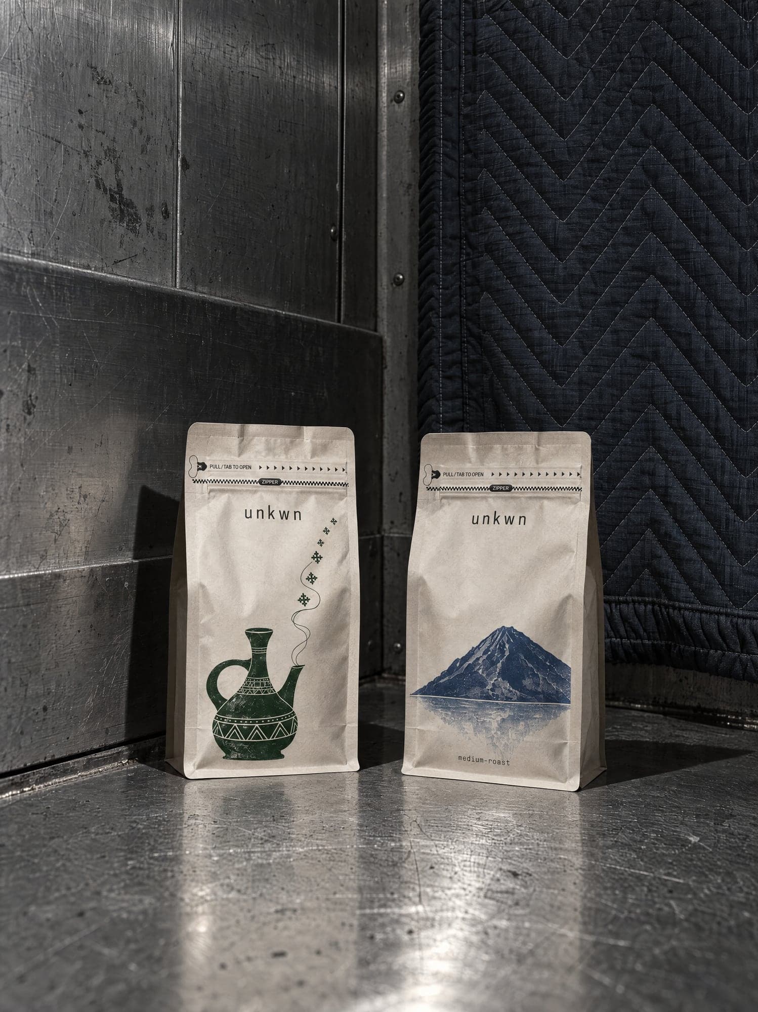 Two unkwn bags on the steel floor of a freight elevator
